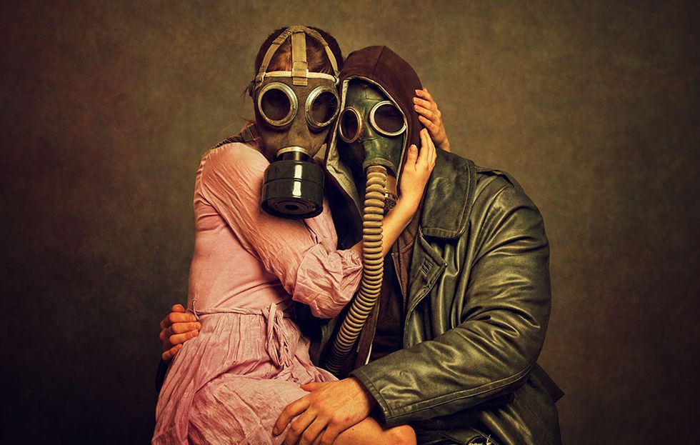 Travel Writing  Two people hugging with gas masks on